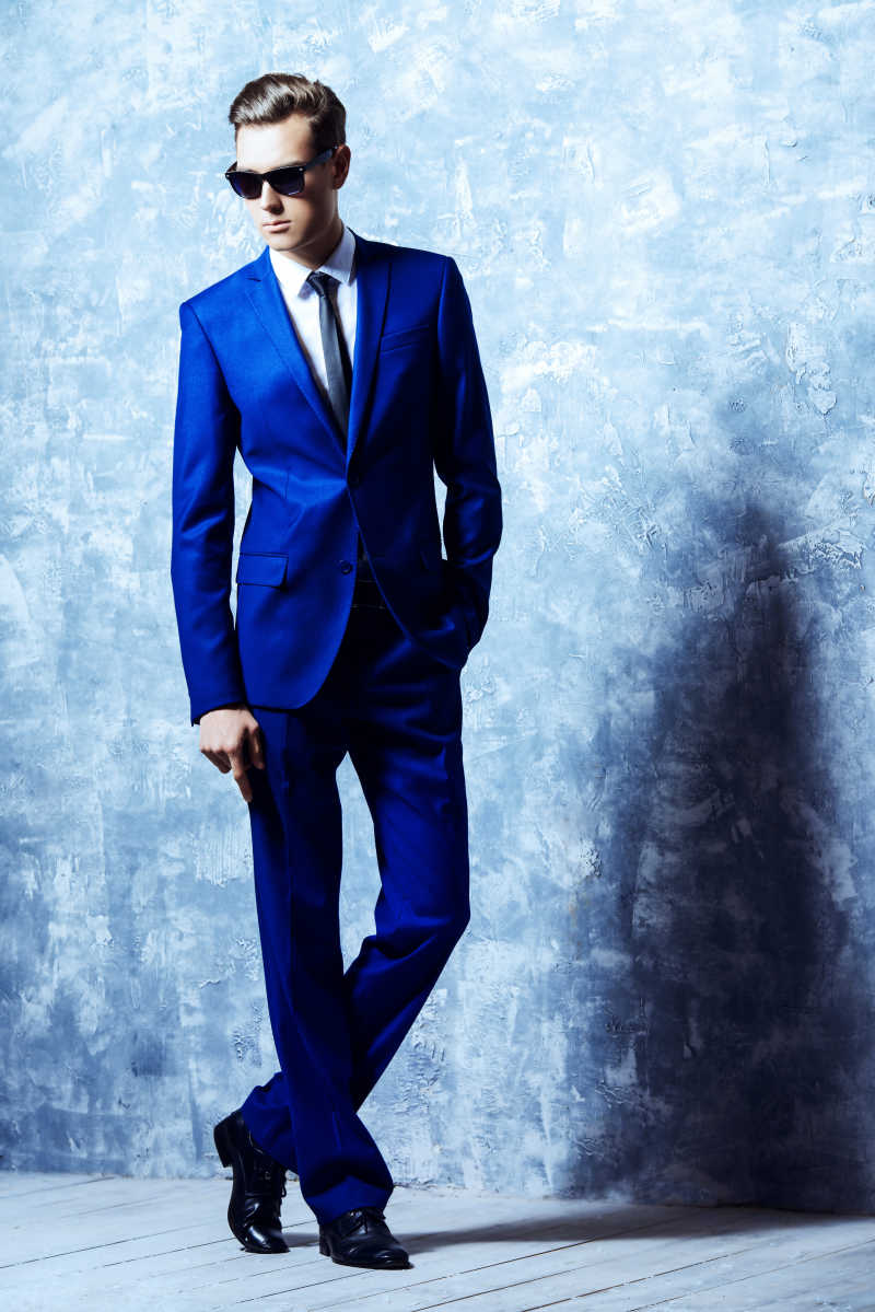 时尚的戴墨镜穿西装的年轻男子