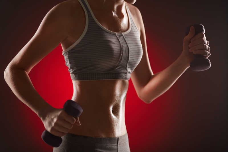 进行哑铃锻炼身体苗条的女性