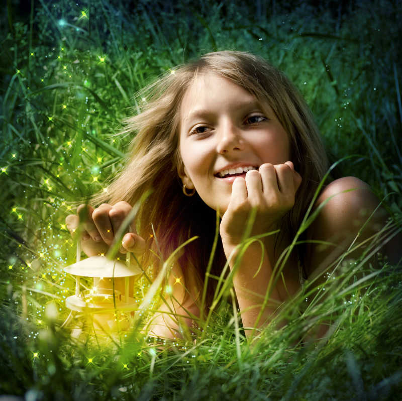 拿着神灯的女孩在草地上