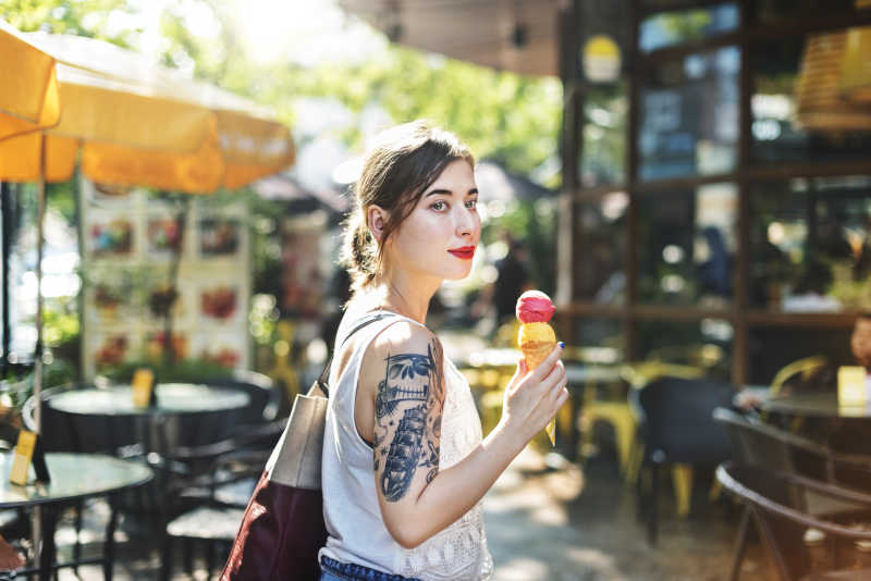  户外有纹身的美女拿着冰激凌