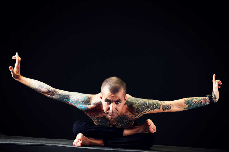 有纹身的男人在做瑜伽
