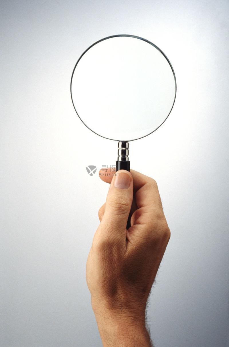 白色背景下握住小放大镜的手