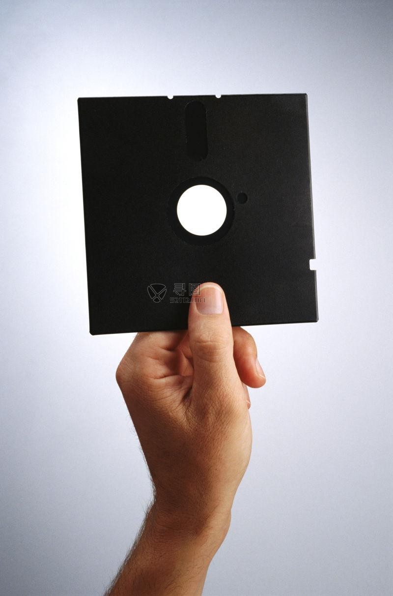 白色背景下手里拿着软盘的