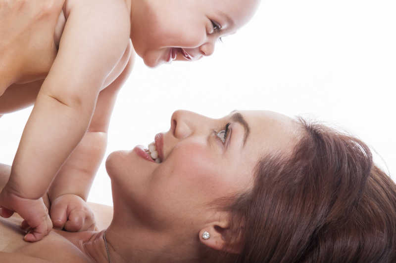 陪婴儿玩耍的年轻妈妈