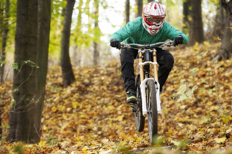 秋天的树林骑车子戴头盔的人