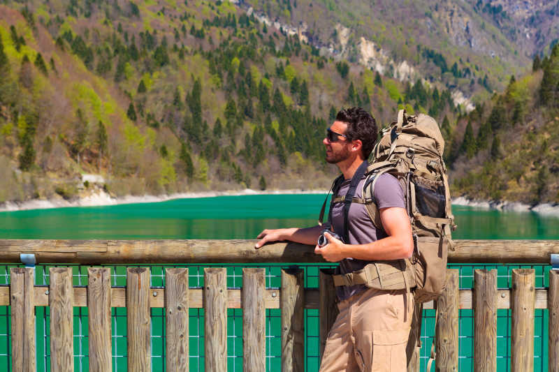 在湖边欣赏风景的背包徒步旅行者