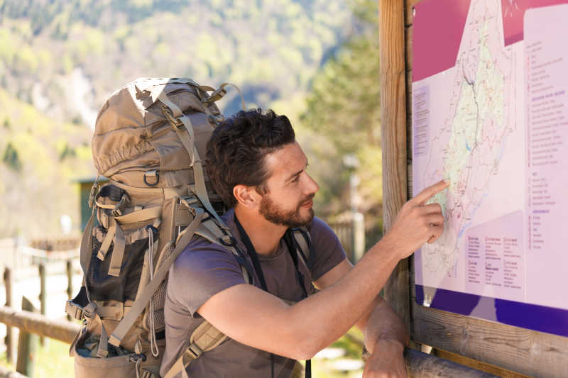 正在研究景区规划地图的背包旅行者