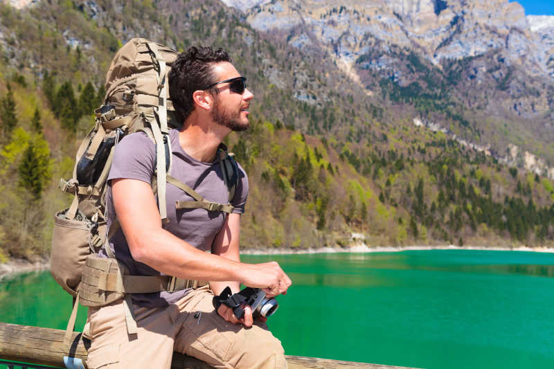 欣赏湖边风景的背包旅行者