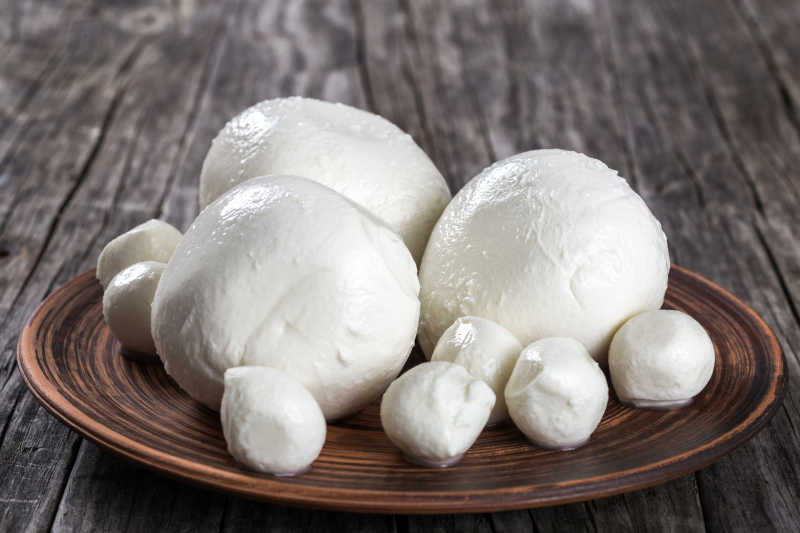 放在一个古老的乡村餐桌上的粘土盘子上的意大利干酪球特写