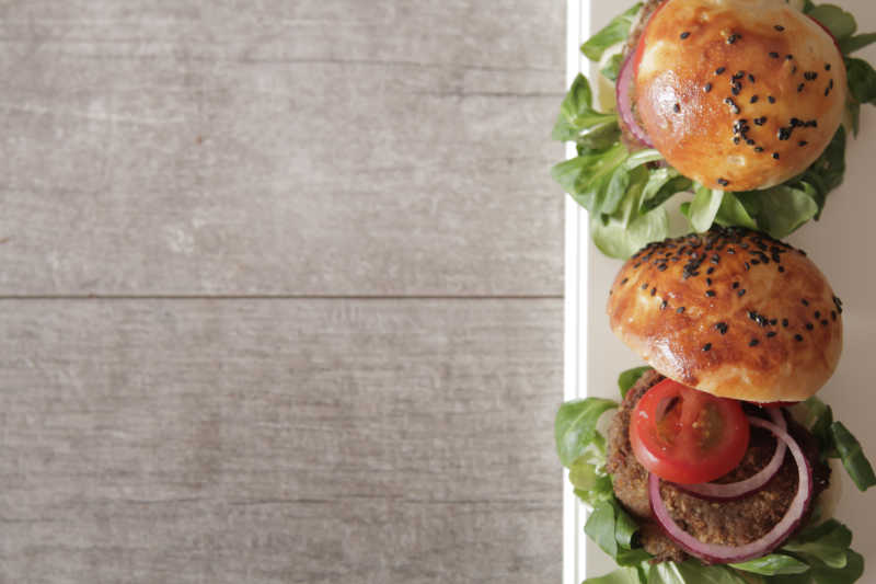 木制背景下的牛肉蔬菜汉堡包