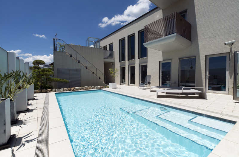 晴天阳光下豪华别墅里的蓝色游泳池