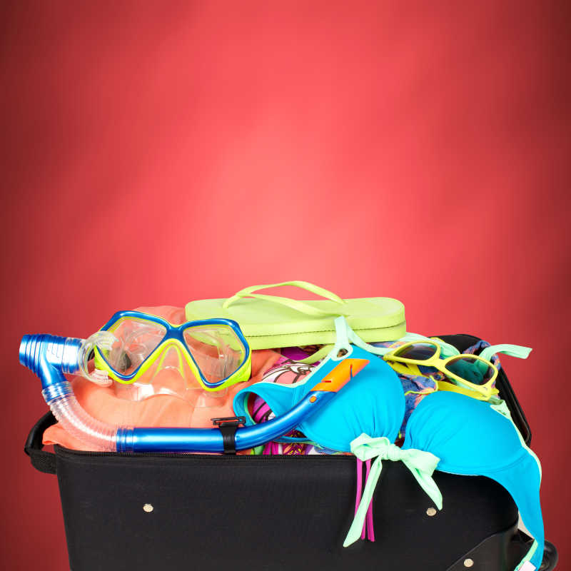 红色背景下的旅行箱