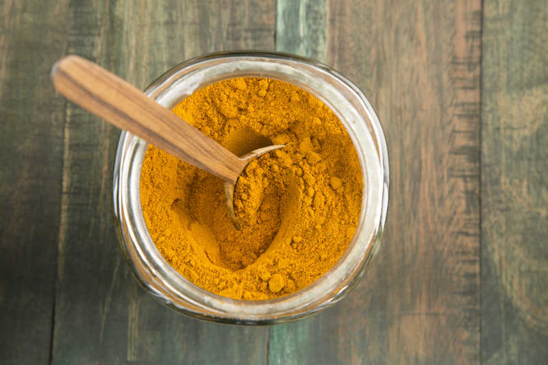 木桌上的玻璃罐里的姜黄粉