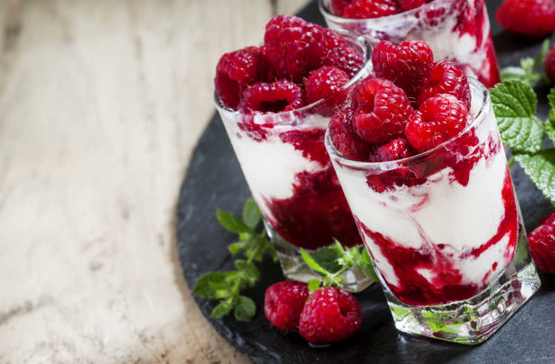 木桌上的薄荷香草冰淇淋配覆盆子