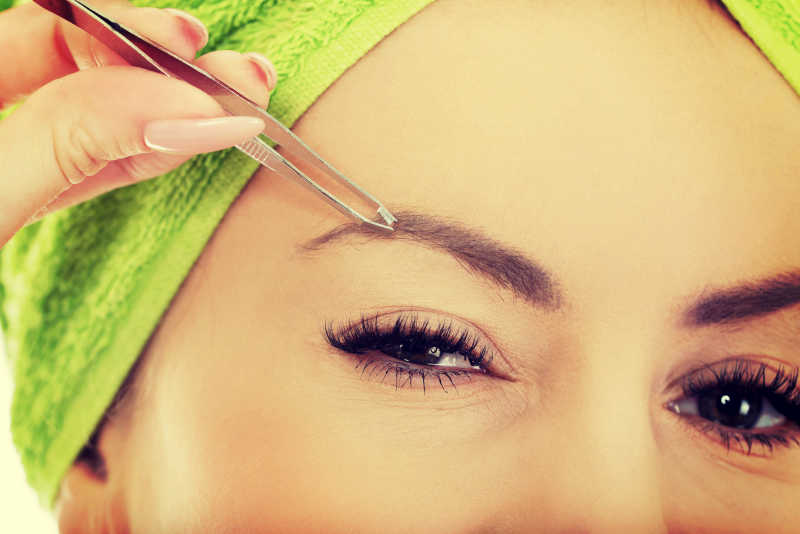 女人拔掉她的眉毛