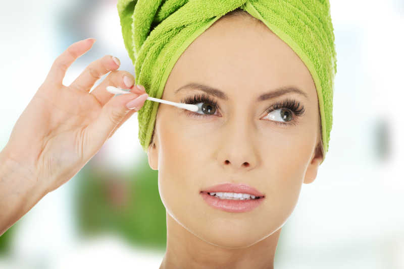 女子使用化妆棉化妆睫毛