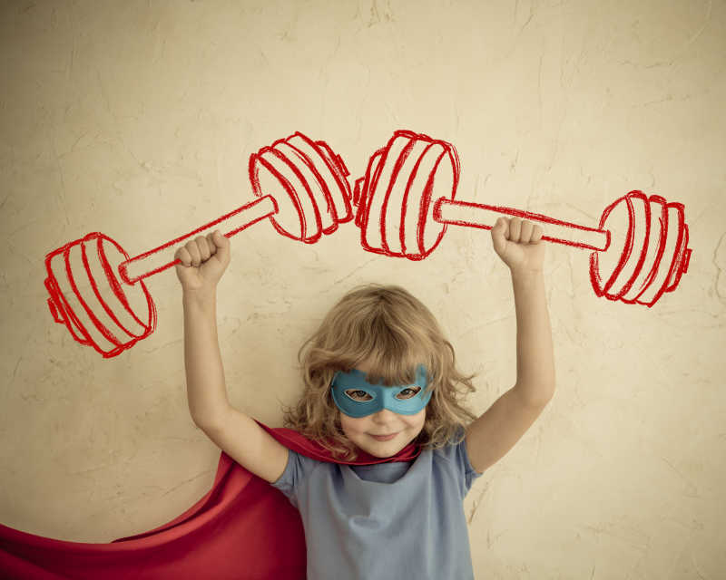 双手举着虚拟杠铃的超级英雄孩子
