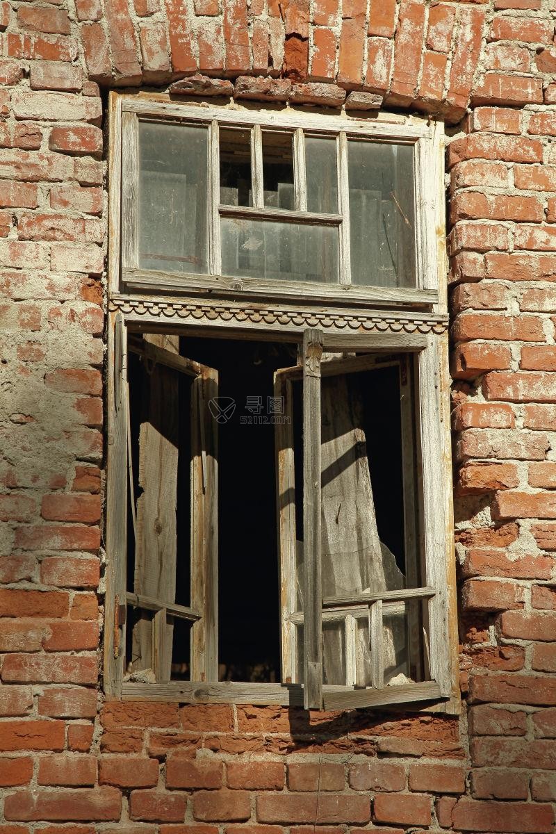 红色砖墙上的古老破旧的木制百叶窗