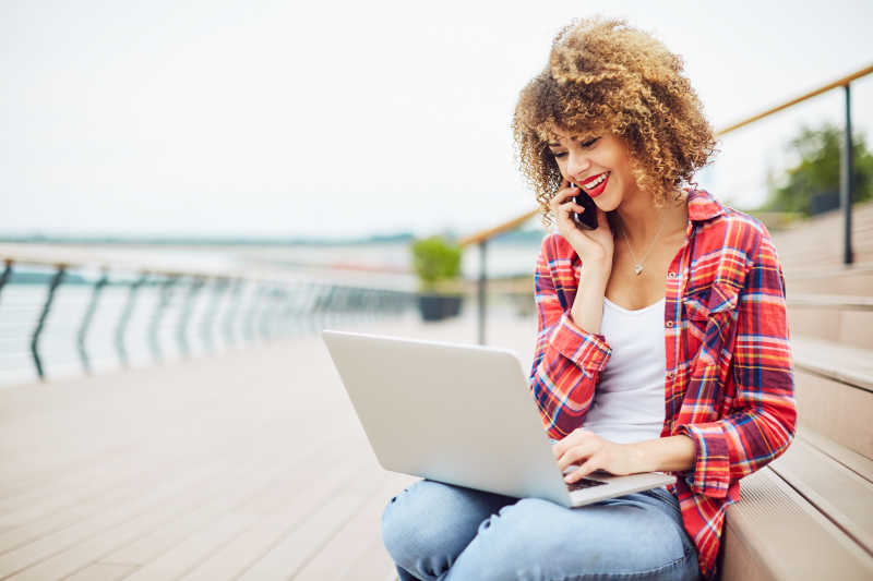 女孩坐在楼梯上跟人打电话