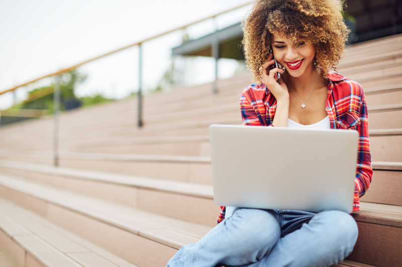 女孩坐在楼梯上工作