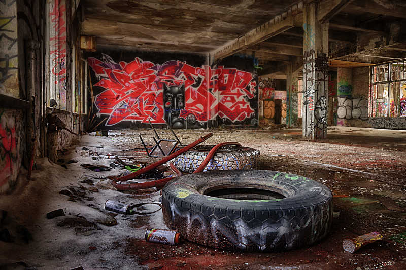 旧房子里的旧轮胎和墙壁上的涂鸦