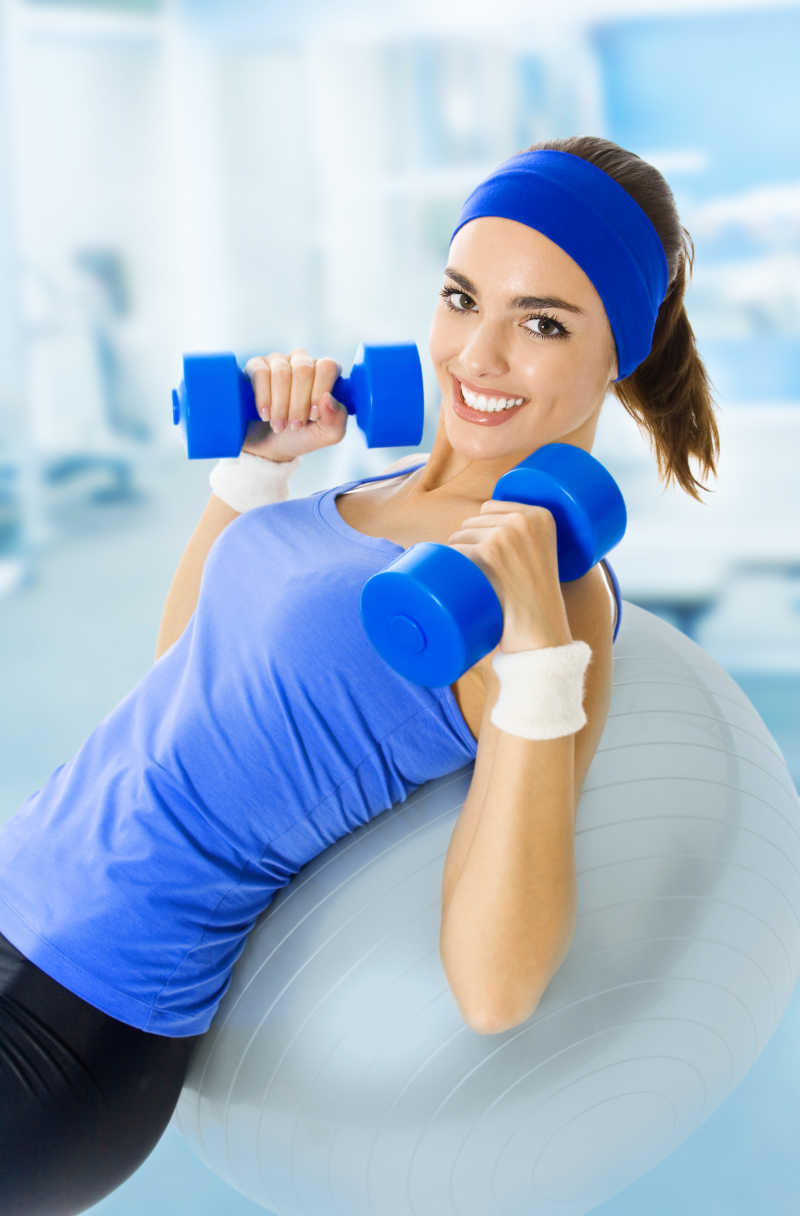 躺在瑜伽球上的美女在做有氧运动