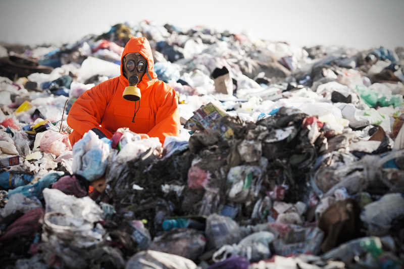 垃圾填埋场中穿着防护服的回收工作者