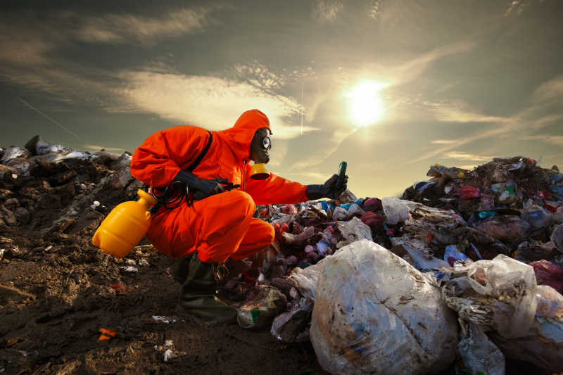 在垃圾填埋场检测垃圾污染的工作人员