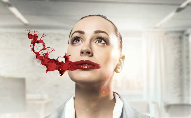 红色口红飞溅在女人的嘴上