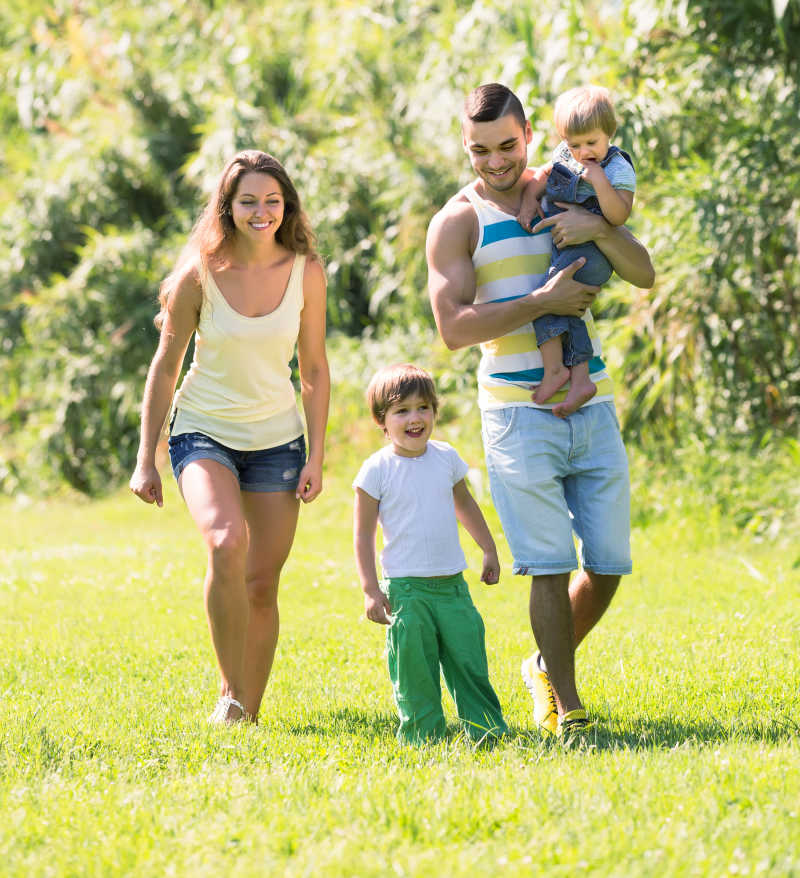 夏日草地上年轻的父母与孩子