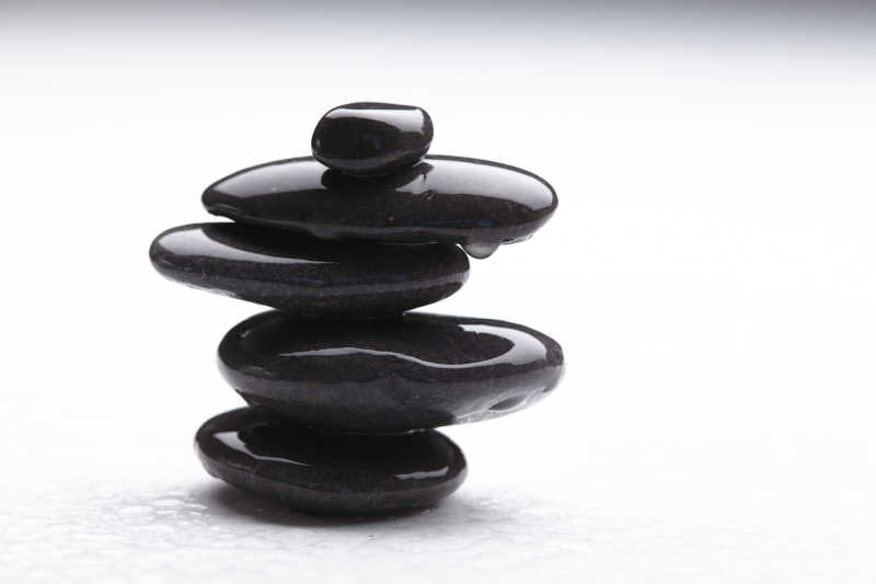 白色背景上黑色堆叠滴水的鹅卵石