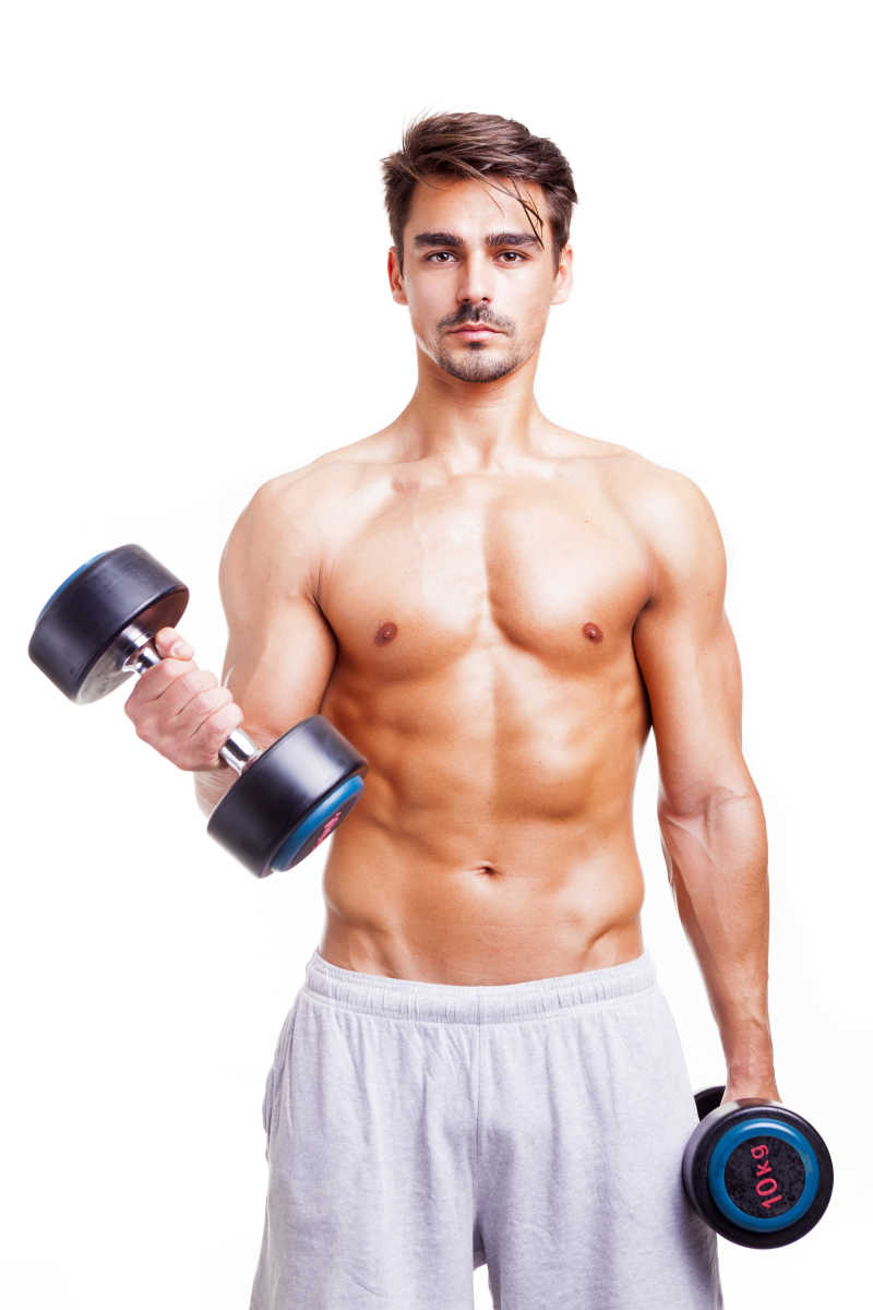 英俊的男子在使用哑铃锻炼