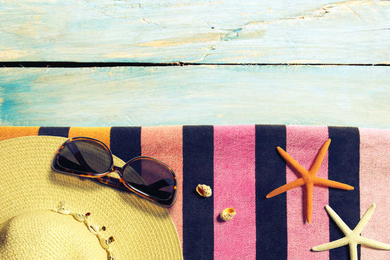 夏天的海滩木板上的太阳镜遮阳帽