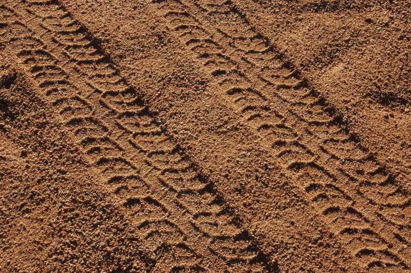 沙子上留着开过车子的轮胎印痕