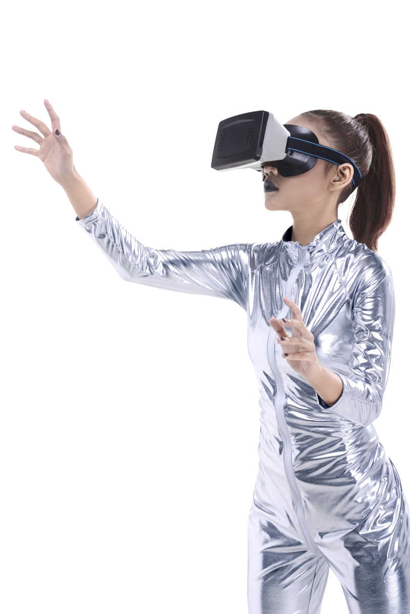 白色背景下戴着VR眼镜的美丽的年轻女子