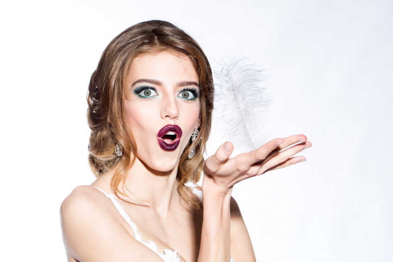 妆容精致的女人拿着羽毛