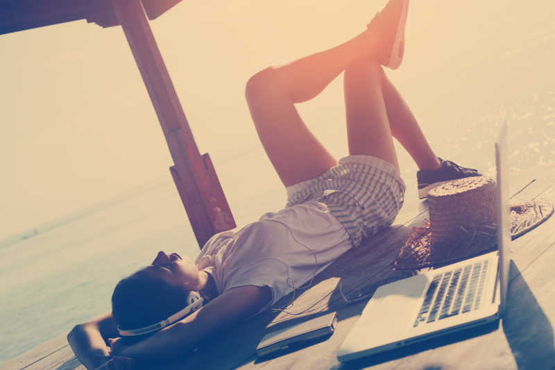 躺着听音乐旁边放着笔记本电脑的美女