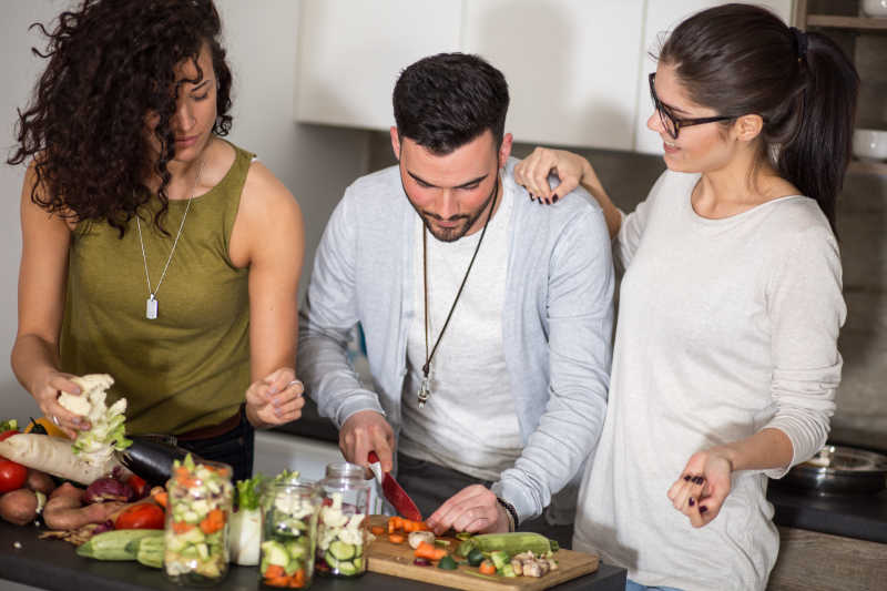 在厨房烹饪的三个年轻人