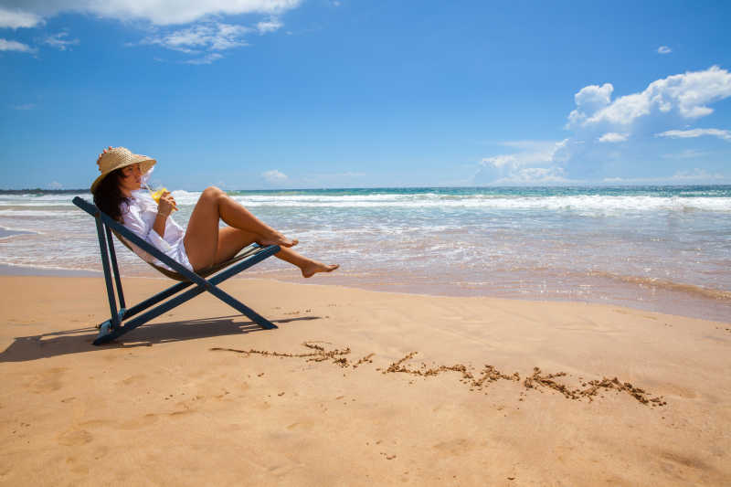 沙滩边躺在躺椅上的年轻女子