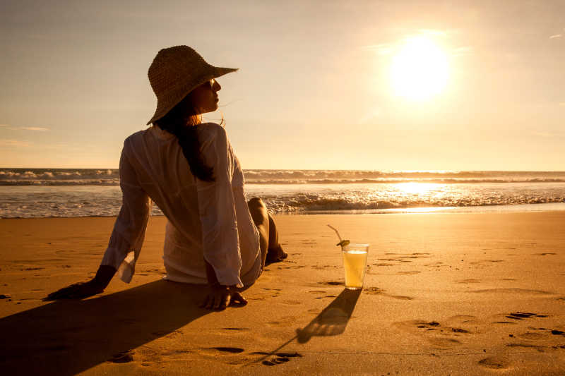 落日海边坐在地上的美女