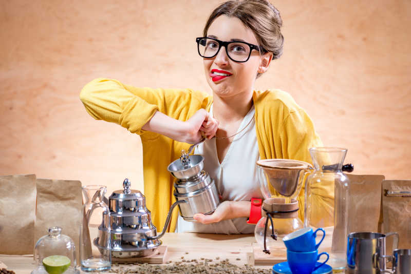 年轻漂亮的女人手工磨碎咖啡豆