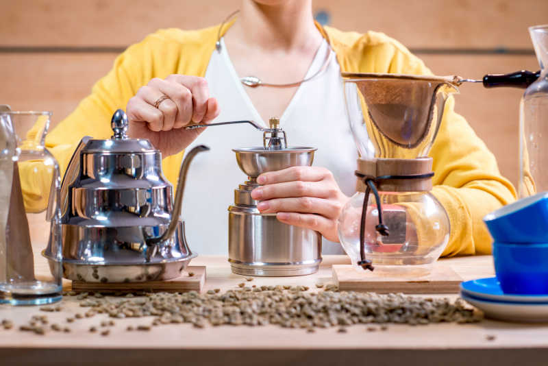 正在自己用手磨碎咖啡豆的女人的手