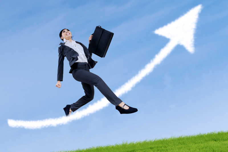 蓝天下跳跃的女商人