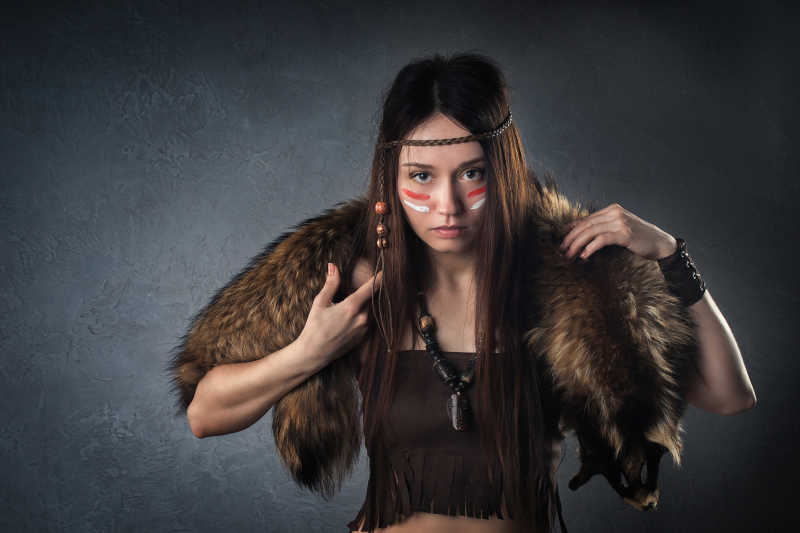 黑色背景下背着猎物的女猎人