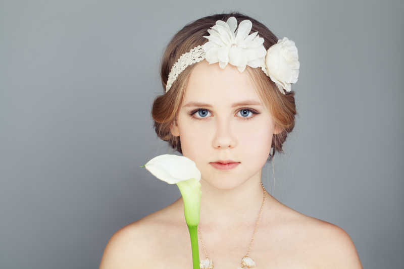 戴着发卡的时髦女孩拿着一束百合