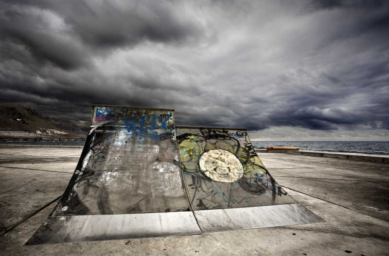 多云的天空下户外画着涂鸦的滑板坡道