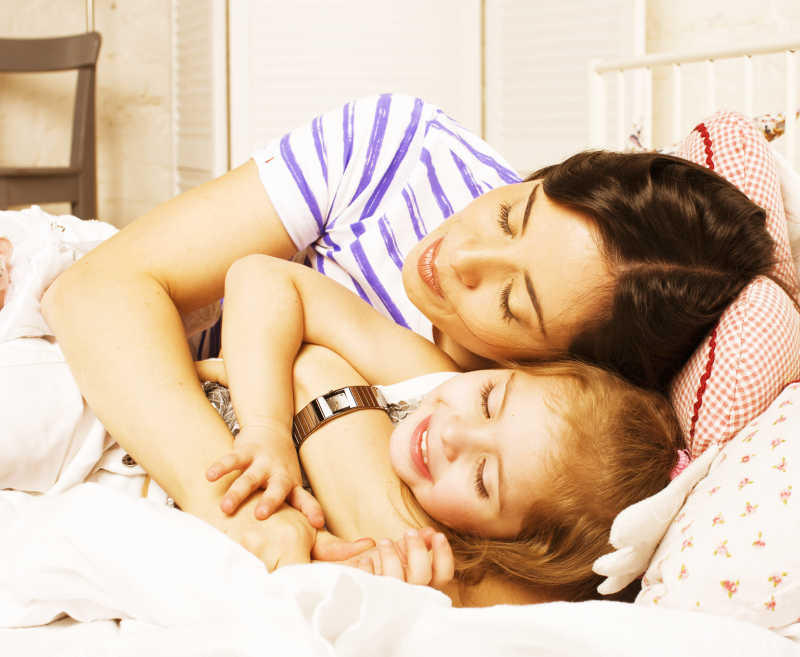 妈妈在家中拥抱着女儿睡觉