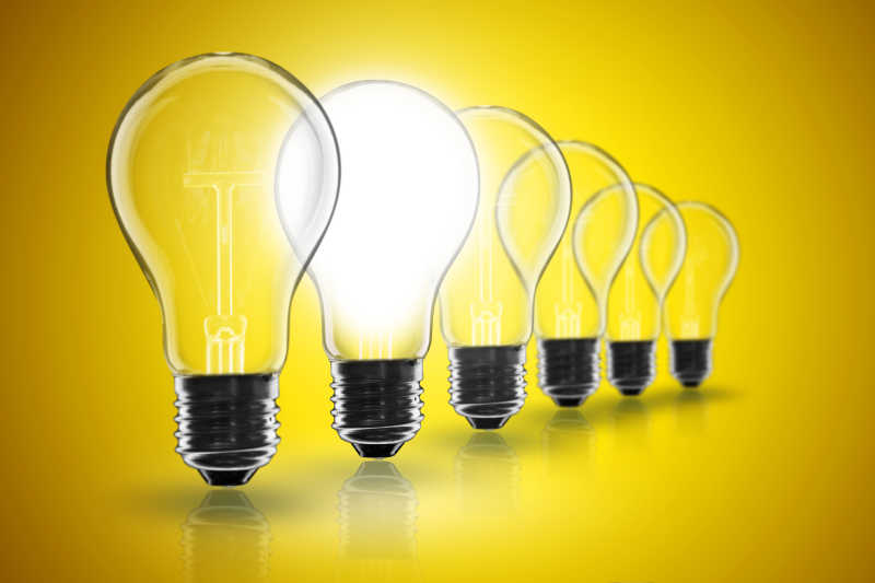 黄色背景下的发光白炽灯
