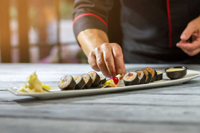 给寿司添加装饰的年轻厨师