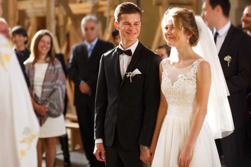 礼堂中接受宾客祝福的幸福的新郎新娘